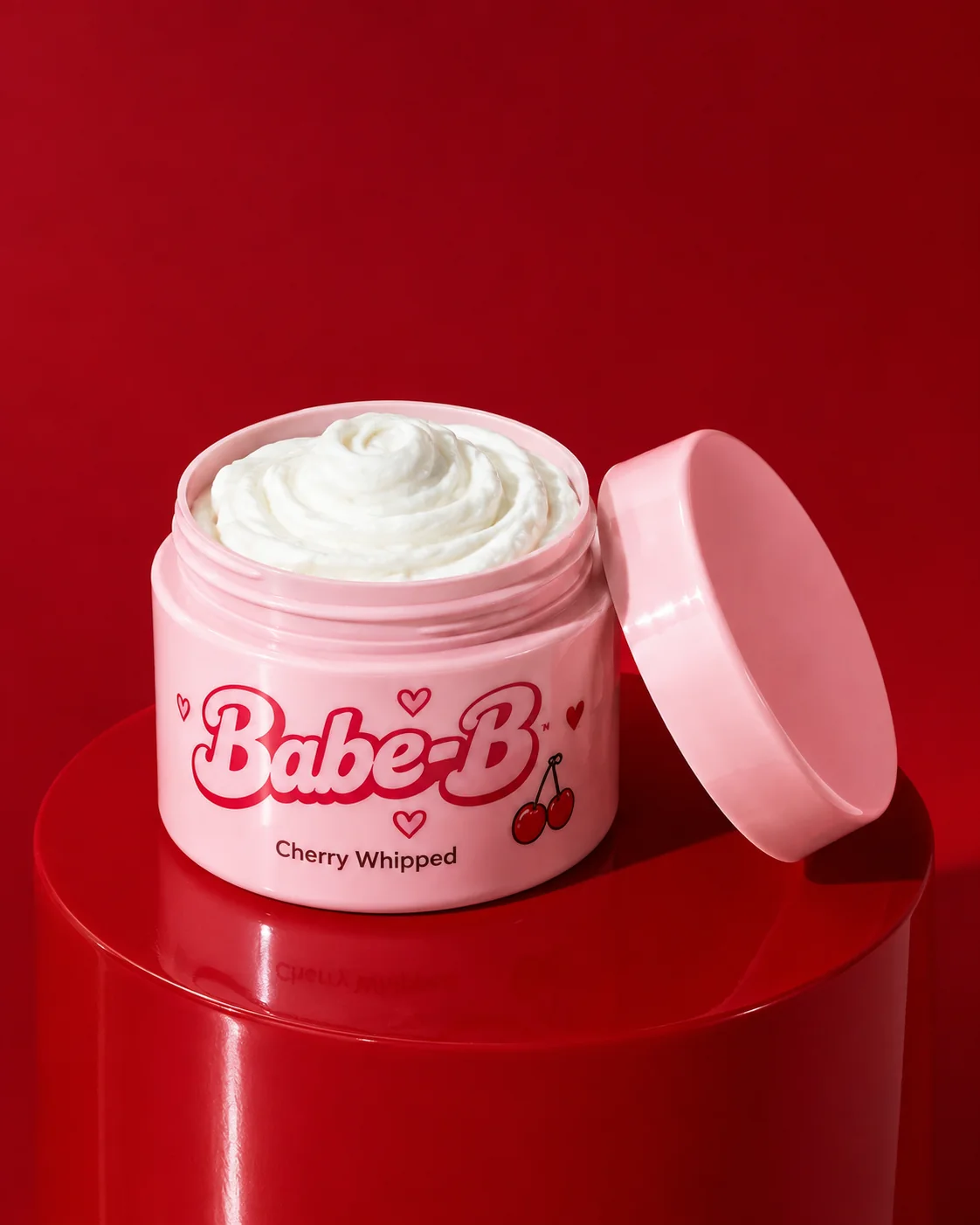 Open pink jar and matching lid on a red pedestal