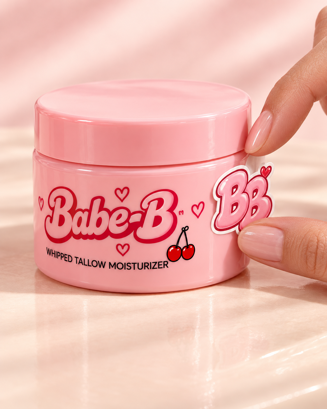 Adult fingertips applying a BB sticker to a closed pink Babe-B shell